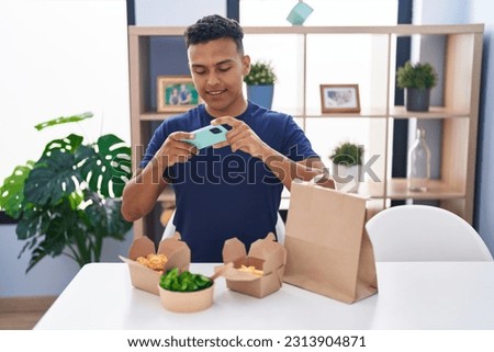 Young latin man make photo to take away food at home