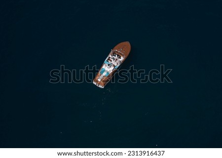High speed wooden big boat with people on dark water top view. Royalty-Free Stock Photo #2313916437