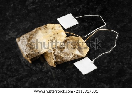 Tea bag. Two used wet tea bags with a blank label on a dark background. Selective soft focus