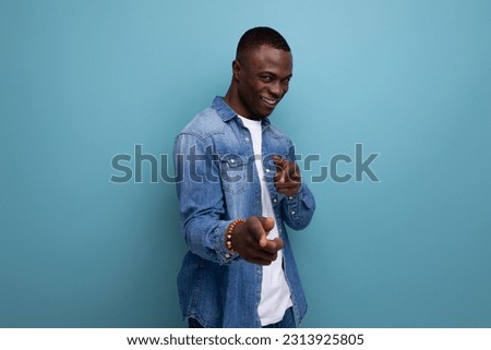 portrait of a 30 year old cheerful perky american man with a short haircut dressed in a denim jacket and a white t-shirt