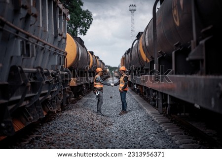 Engineer railway show best hand shake cooperation inspection, checking train testing and checking railway work on railroad station with Engineer wearing safety uniform and safety helmet in work. Royalty-Free Stock Photo #2313956371