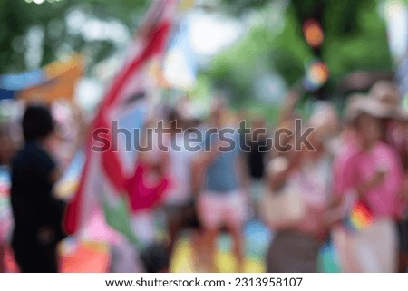 Burl image of pride parade holding the Pride Union Jack flags, flags in street pride parades during Pride Month celebrations