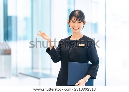 Asian female staff guiding in the lobby. Royalty-Free Stock Photo #2313992313