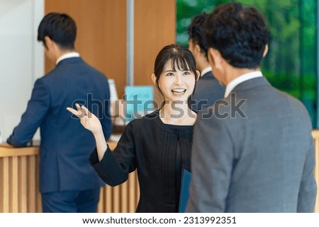 An usher woman serving tourists at the front desk. Hotelier. Royalty-Free Stock Photo #2313992351