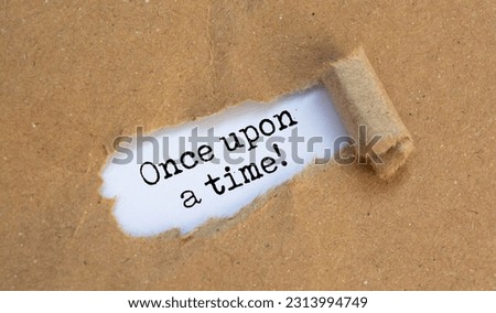 once upon a time, text on white paper on torn craft paper Royalty-Free Stock Photo #2313994749