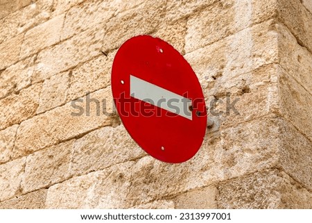 Do not enter sign hanging from a brick stone background wall. Communication and safety concept