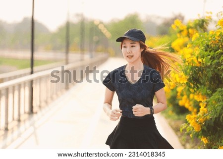 Young woman running on city road morning,woman fitness silhouette sunrise jogging workout wellness concept.