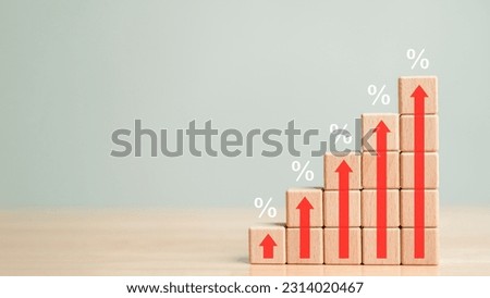 Rising percentage Interest rate financial bar chart with high up arrow and housing mortgage rates on wooden blocks background. Business symbol and economic development success market share concept.