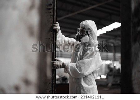 Industrial waste inspector wearing personal protective equipment to check hazardous chemicals, radioactive and toxic substances. Analyzing impact of factory's current projects, suggesting solutions. Royalty-Free Stock Photo #2314021111