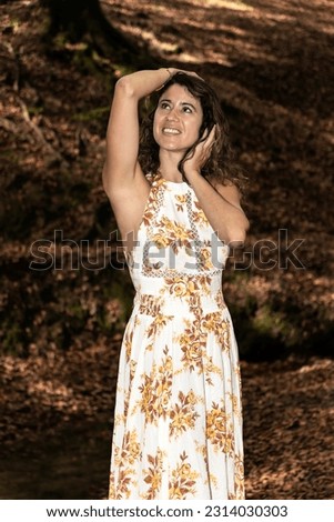 Captivating Brunette Woman Poses in a Summer Dress amidst the Forest