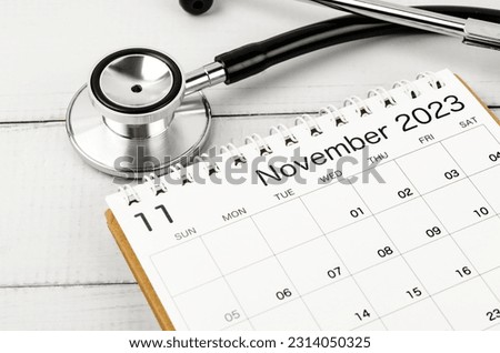 Stethoscope medical and November 2023 calendar wooden background, schedule to check up healthy concepts.