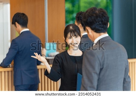 An usher woman serving tourists at the front desk. Hotelier. Royalty-Free Stock Photo #2314052431