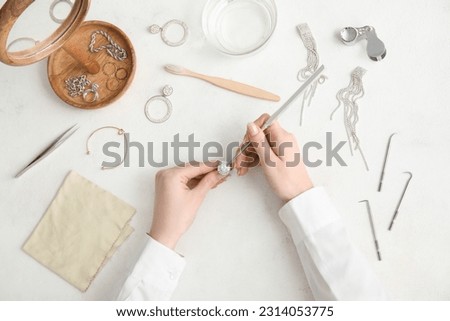 Female hands with beautiful ring, cleaning tools and jewelry on light background