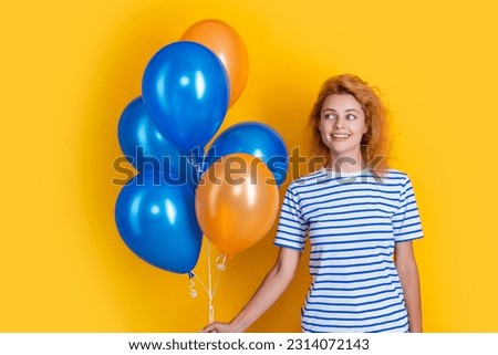 cheerful woman hold party balloons in studio. woman with balloon for party isolated on yellow