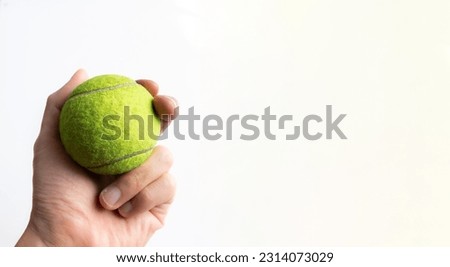 Hand holding a tennis ball, after some edits. Royalty-Free Stock Photo #2314073029
