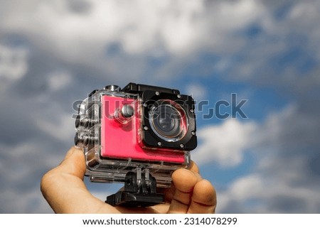 Action camera in protective box in hands.