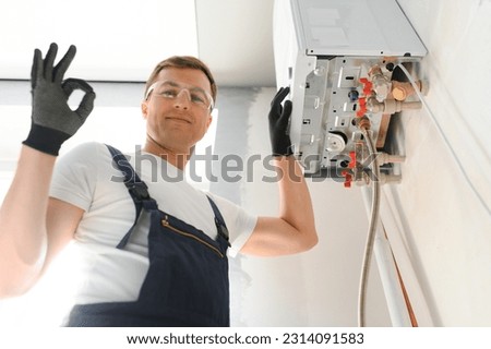Professional boiler service: qualified technician checking a natural gas boiler at home. Royalty-Free Stock Photo #2314091583