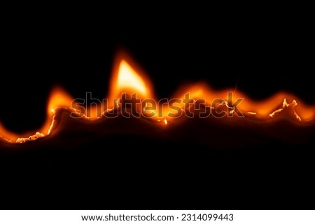 burning paper, glowing edge of paper on a black background Royalty-Free Stock Photo #2314099443