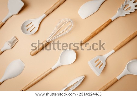 Kitchen silicone utensils for cooking tools on light orange background, top view, flat lay. Kitchenware collection with copy space. Cooking background. Royalty-Free Stock Photo #2314124465