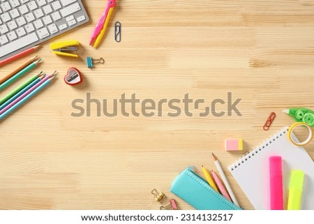 School supplies frame on wooden desk. Top view. Flat lay. Royalty-Free Stock Photo #2314132517