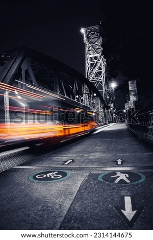 A mesmerizing shot of a Hawthorne Bridge and a train in a motion at night