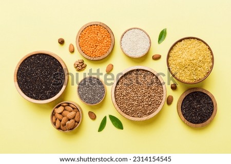 Various superfoods in smal bowl on colored background. Superfood as rice, chia, quinoa, lentils, nuts, sesame seeds, almonds. top view copy space. Royalty-Free Stock Photo #2314154545
