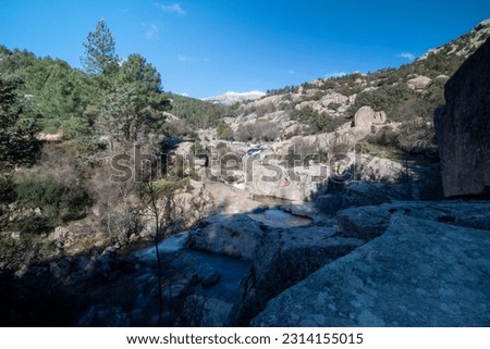 A panoramic image capturing the majestic mountains of La Pedriza with the winding river in the foreground.