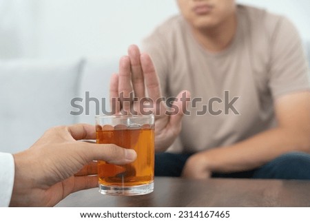 man refuses say no and avoid to drink an alcohol whiskey , stopping hand sign male, alcoholism treatment, alcohol addiction, quit booze, Stop Drinking Alcohol. Refuse Glass liquor, unhealthy, reject Royalty-Free Stock Photo #2314167465