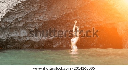 Woman travel sea. Happy Woman traveler shares adventure journey at sea, surrounded by volcanic mountains on beach. Happy tourist captures memory in pink bikini.