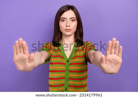 Portrait of confident woman activist wear trendy clothes showing gesture stop sexism isolated on purple color background Royalty-Free Stock Photo #2314179961