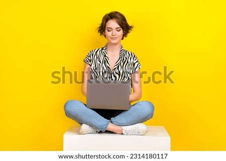 Full length photo of cheerful positive woman dressed zebra striped shirt working modern device isolated yellow color background
