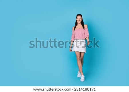 Full length body of attractive young chinese lady brunette posing model walk showing her stylish outfit isolated on blue color background