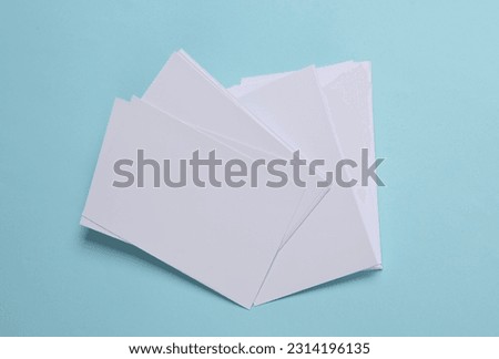 Mockup of white blank sheets of paper or photographs on a blue background