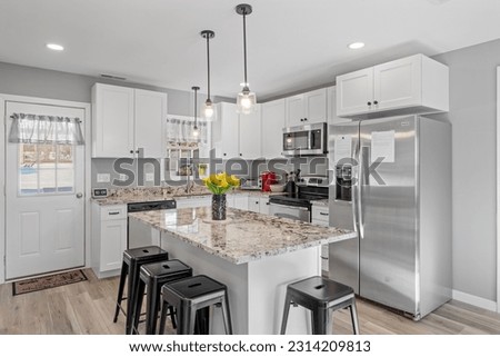 A modern kitchen with white walls and cabinets, featuring stainless steel appliances Royalty-Free Stock Photo #2314209813