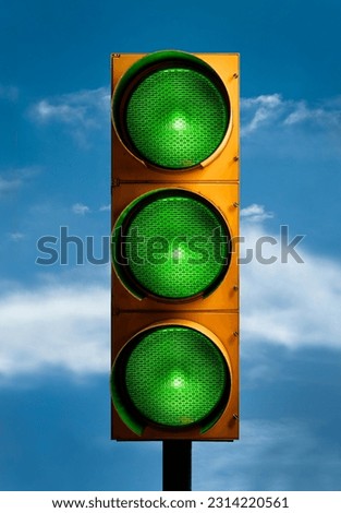 A vertical closeup shot of a traffic light with all green lights against the blue sky Royalty-Free Stock Photo #2314220561