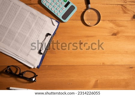 wooden desktop with dokument and book,eyeglass