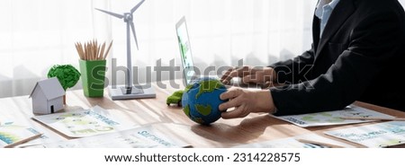 Businessman or CEO of the green corporate company holding paper Earth as concept for environmental friendly business to reduce CO2 emission and carbon footprint for cleann ecology. Trailblazing Royalty-Free Stock Photo #2314228575