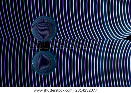Long exposure photography with light painting technique. Glass sphere and its reflections with curved lights. abstract photography
