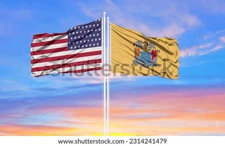 United States and New Jersey two flags on flagpoles and blue sky
