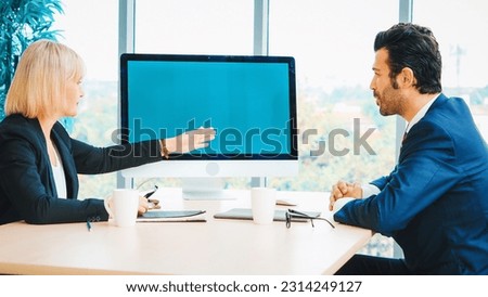 Business people in the conference room with green screen chroma key TV or computer on the office table. Diverse group of businessman and businesswoman in meeting on video conference call . Jivy