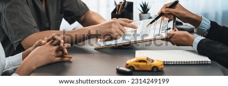 Car dealer calculate interest rate and costs of car loan, offering financial and insurance service while customer client reading on term and agreement on contract in dealership office. Prodigy
