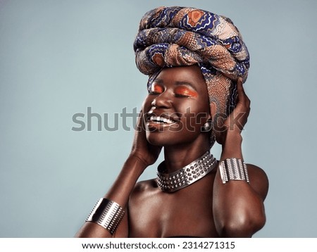 Beauty, black woman and smile with African head scarf and mockup in a studio. Isolated, blue background traditional Africa turban with a young female model with culture and pride with cosmetics Royalty-Free Stock Photo #2314271315