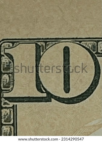 Close up view of the number ten on a the United States currency.