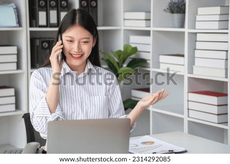 Asian businesswoman talking on the phone working in modern office Chat with clients for a new way of doing business in the office.