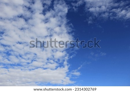Half of the blue sky is covered with white clouds.