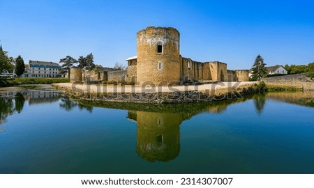 Reflection of the round corner tower of the medieval castle of Brie Comte Robert in the water-filled moat in the French department of Seine et Marne in the capital region of Ile-de-France near Paris