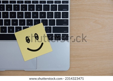 Symbol smile face paper office laptop computer keyboard on table background.
Feedback employee team positive business,
World mental health day, 