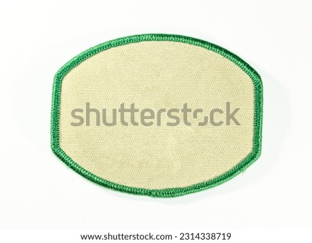 Tan oval emblem patch with green trim. Royalty-Free Stock Photo #2314338719