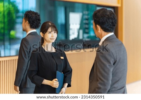An usher woman serving tourists at the front desk. Hotelier. Royalty-Free Stock Photo #2314350591