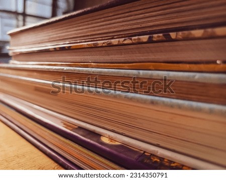 Organized hardcover books on a wooden table. Close-up view. Book collection.